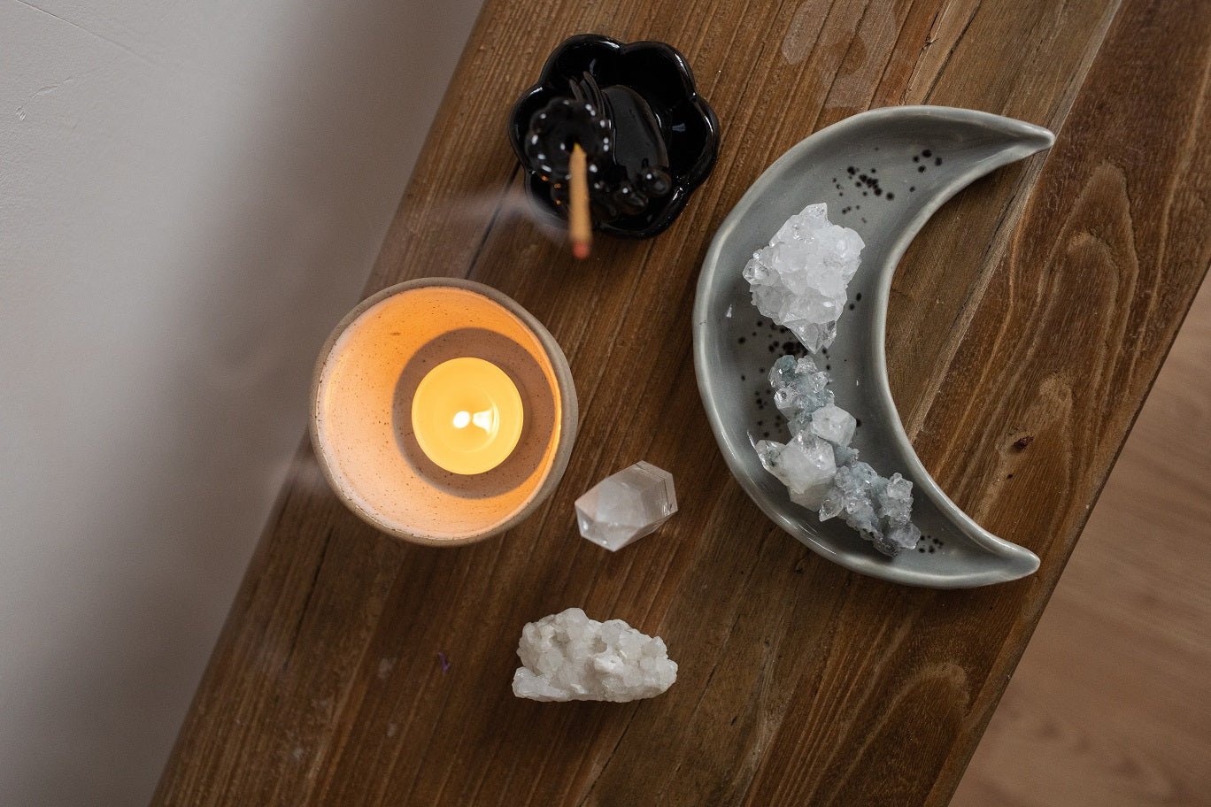 The candle on the shelve with aroma stick and crystals in the bowl